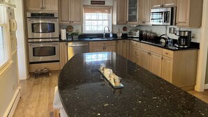 Una cocina moderna con electrodomésticos integrados, una isla grande y armarios de madera.