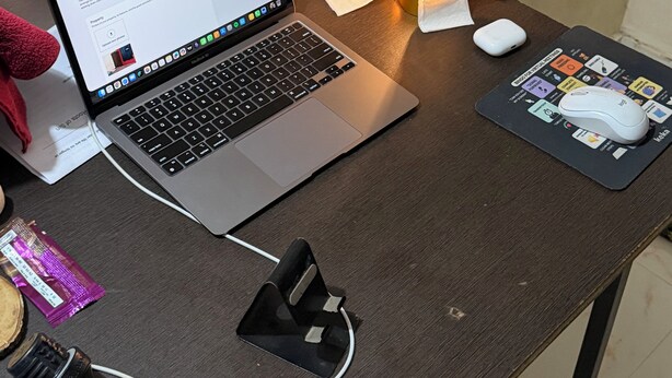 Un ordinateur portable sur un bureau, avec une souris, un multiprise et une lampe.