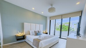 Quarto de hotel moderno com uma cama grande, uma mesa de escritório e vista para a cidade.