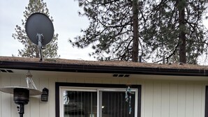 Ein Haus mit Satellitenschüssel, Laterne und Mülleimer.