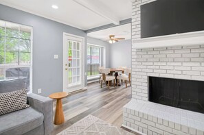 Una sala de estar con chimenea, un comedor y un sofá.
