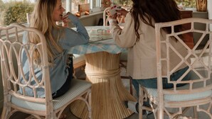 Techo de madera, una mesa con sillas y vistas a través de amplios ventanales.