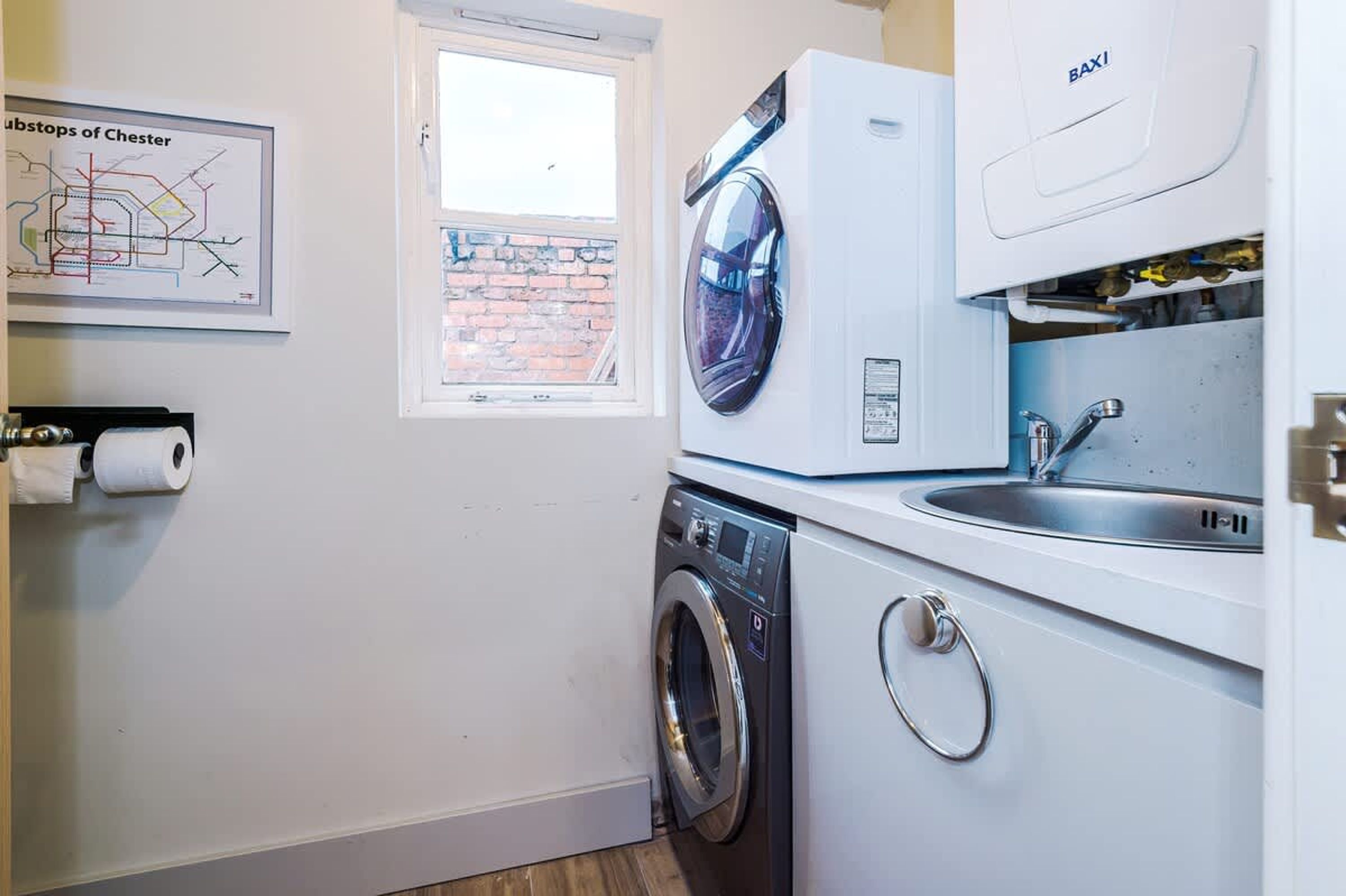 A laundry area with a washing machine, dryer, and sink.
