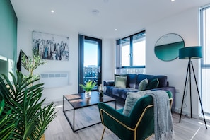 A modern living room with a sofa, a coffee table, and a potted plant. - Stunning 2-bed Flat Amazing Location Sleeps 4 (Liverpool)