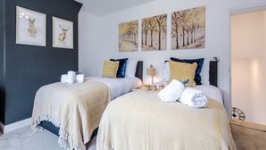A hotel room with two beds, a nightstand, and wall art. - Gorgeous 3-bed Home Amazing Location Sleeps 7 (Nantwich)