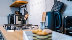 A kitchen with a gas stove, a kettle, and a plate of food. - NEW Spacious Stylish Home City Centre Sleep 4 (Chester)
