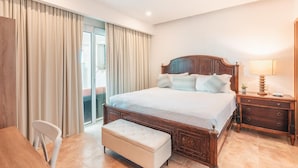 Camera d'albergo con un letto di legno, un comodino, una sedia, una panca e vista all'esterno.