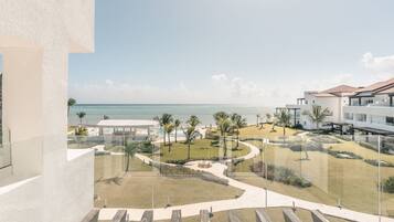 Un complex turístic amb piscina, palmeres i vistes a l'oceà.