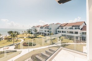 A modern hotel with a pool, outdoor seating, and a view of the ocean. - Studio for two w Ocean View at Punta Palmera Gc5 (Punta Cana)