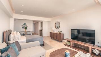 Een moderne hotelkamer met een bed, een bank, een televisie en een zithoek.