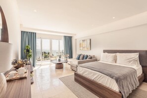 Une chambre d’hôtel moderne dotée d’un grand lit, d’un canapé, d’une table à manger et d’un balcon avec des rideaux.