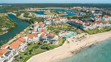 Un resort con varias edificaciones, una playa y una piscina.