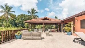 A covered outdoor area with a pergola, seating, and potted plants. - 5br Villa Nearby the Beach w Pool in Casa de Campo (La Romana)
