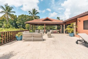 A covered outdoor area with a pergola, seating, and potted plants. - 5br Villa Nearby the Beach w Pool in Casa de Campo (La Romana)