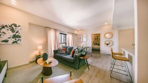 A modern living room with a sofa, a round coffee table, and a dining area with a bar. - Regatta Living 906 (Santo Domingo)