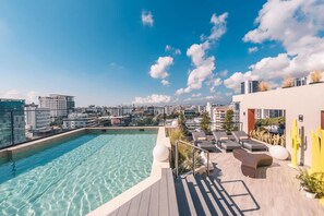 A rooftop pool with clear water, lounge chairs, and a city view. - Regatta Living 906 (Santo Domingo)