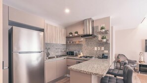 A modern kitchen with a stainless steel refrigerator, granite countertops, a gas stove, and a built-in microwave. - Flat in Regatta Ii With Breakfast Included 204 (Santo Domingo)