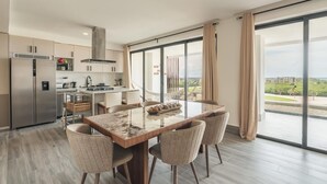 A modern kitchen with a dining area, large windows, and a view of the city.