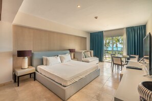 A hotel room with a large bed, a desk with a computer, and a view of the ocean. - Apartment With Ocen View at Punta Palmera Cb4 (Punta Cana)