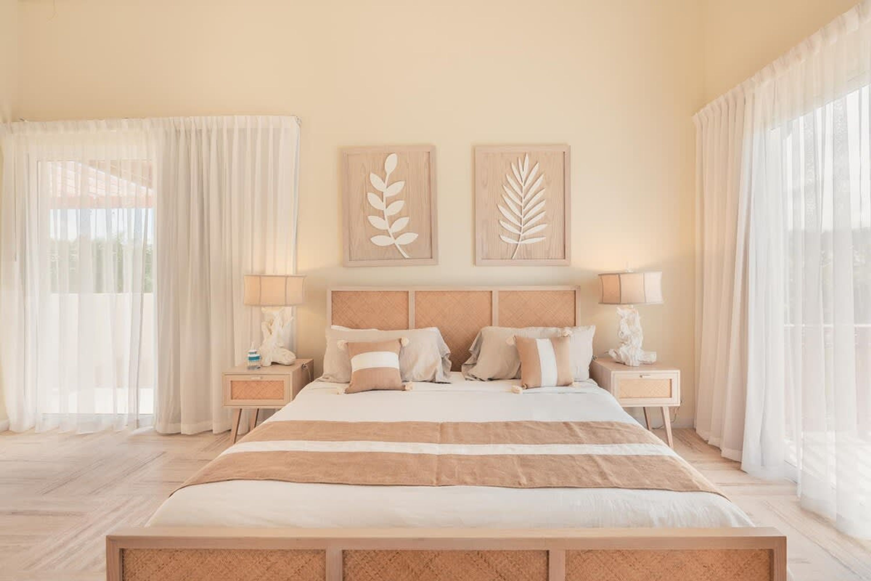 A bedroom with a large bed, two bedside tables, and a headboard.