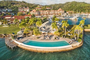 A resort with a large pool, palm trees, and a marina. - Brkfst Included Private Pool at Puerto Bahia B4 (Samaná)