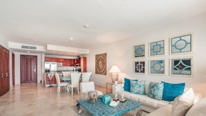 A modern living room with a sofa, coffee table, and artwork on the wall. - Apartment few Steps to the Beach at Punta Palmera (Punta Cana)