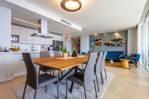 Eine moderne Küche mit Essbereich, einem blauen Sofa und einem Gemälde an der Wand.