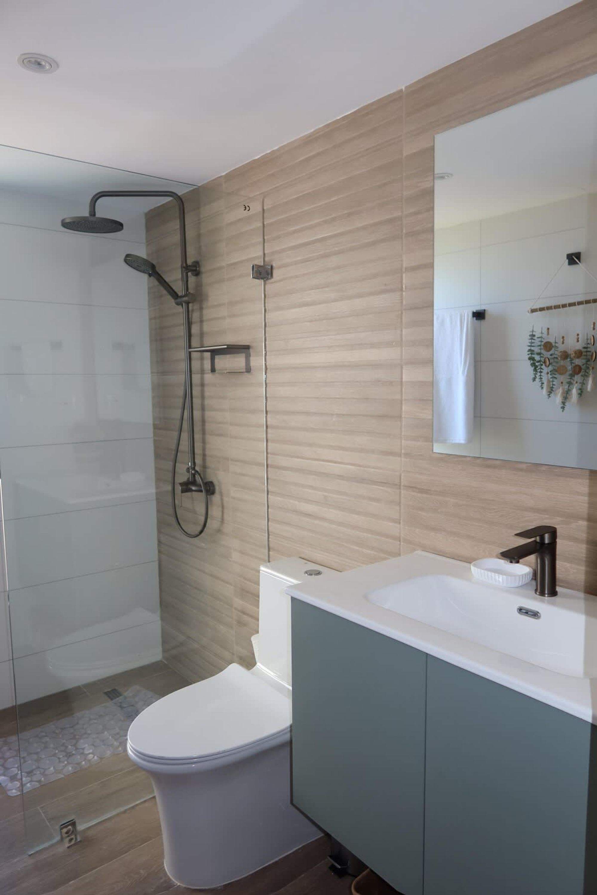 Une salle de bain moderne équipée d’une douche, de toilettes et d’un lavabo.