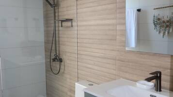 Une salle de bain moderne équipée d’une douche, de toilettes et d’un lavabo.