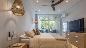 A modern bedroom with a bed, a TV, a ceiling fan, and a view of the outdoors. - 3br-apt 6 Guests Jacuzzi Calablanca (Cartagena)