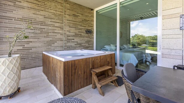 A spa area with a hot tub, wooden seating, and a view of a bedroom through glass doors. - 3br-apt 6 Guests Jacuzzi Calablanca (Cartagena)