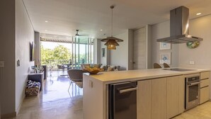 A modern kitchen with a central island, stainless steel appliances, and a dining area with a glass door leading to an outdoor space. - 3br-apt 6 Guests Jacuzzi Calablanca (Cartagena)