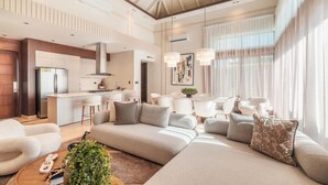 Una sala de estar moderna con un sofá, una mesa de centro y una cocina al fondo.