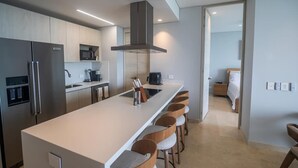 Una cocina moderna con una isla central, electrodomésticos de acero inoxidable y una zona de asientos tipo barra.