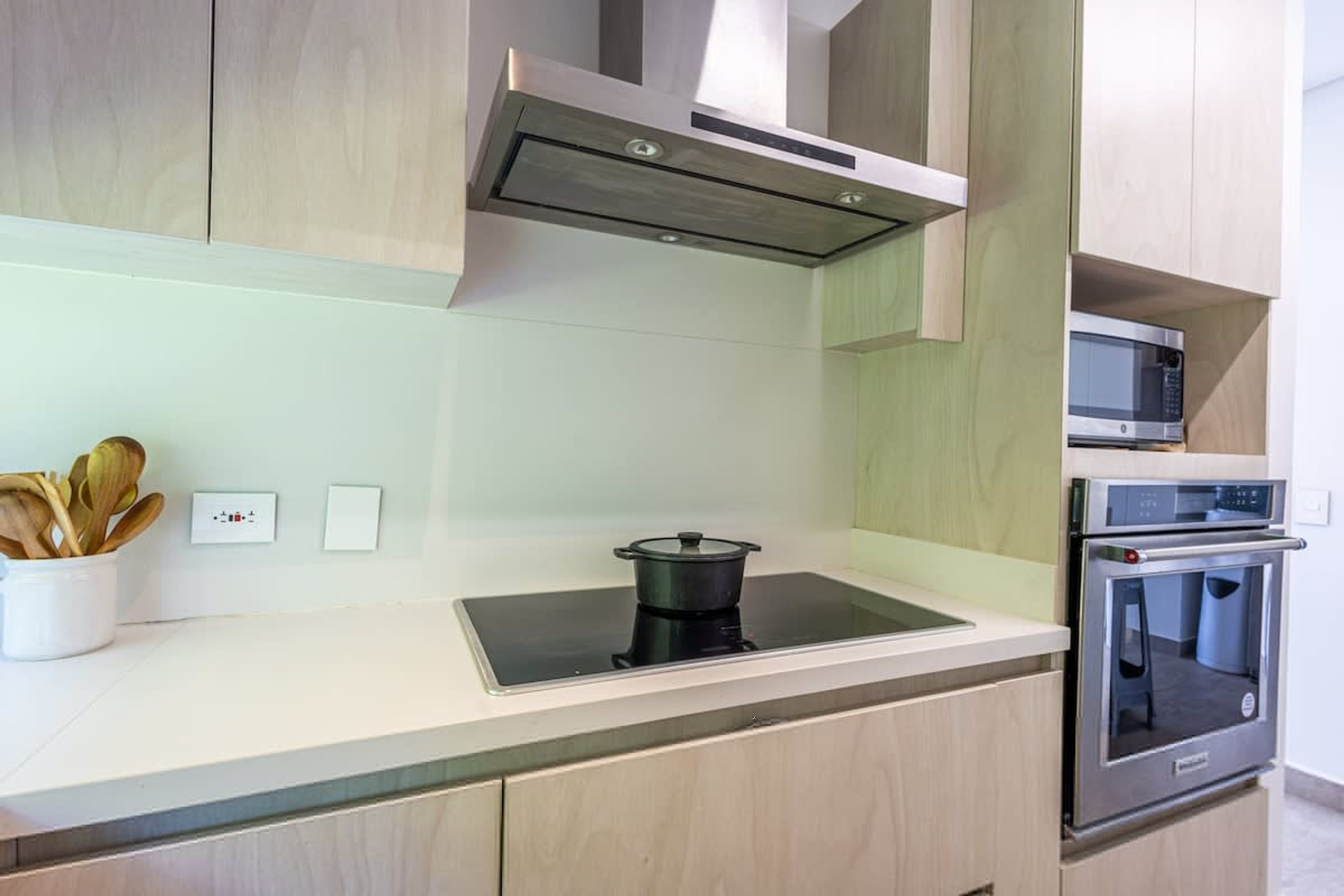 A modern kitchen with a built-in stovetop, oven, and microwave.