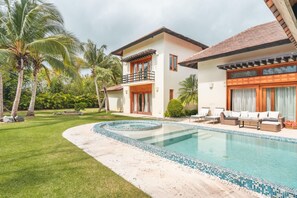 A two-story house with a swimming pool, surrounded by palm trees and a well-maintained lawn. - Amazing Villa w Pool Maid BBQ at Green Village (Punta Cana)