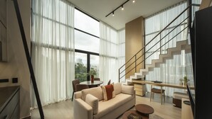 A modern living room with a sofa, coffee table, and a staircase. - Relaxing 2br Apt at Coco del mar (Panama City)