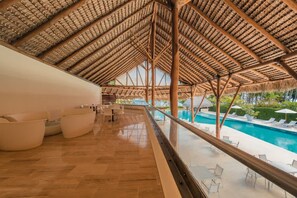 A spacious indoor area with a high ceiling, a pool, and outdoor seating. - Retreat Apartment With 3 Bedrooms in Portillo Nf (Las Terrenas)