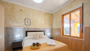 A bedroom with a bed, bedside tables, a window, and a tray with items. - Sunnyvalley by Fidalsa (Dolores)
