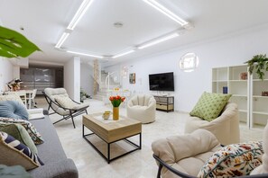 A modern living room with a sofa, armchairs, a coffee table, a TV, and a bookshelf. - Coral Seashell Ground Floor by Fidalsa (Guardamar del Segura)