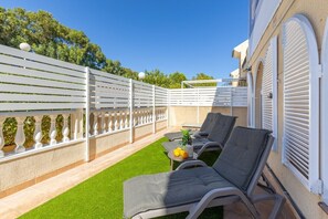 A patio with artificial grass, white lattice fence, and lounge chairs. - Coral Seashell Ground Floor by Fidalsa (Guardamar del Segura)