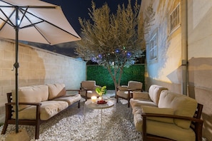 An outdoor seating area with a white umbrella, beige sofas, and a small table with candles. - Blue Lagoon by Fidalsa (Torrevieja)