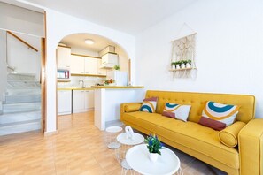 A modern living room with a mustard sofa, white coffee table, and a kitchen in the background. - Blue Lagoon by Fidalsa (Torrevieja)