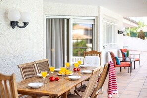A wooden dining table with chairs, a glass of orange juice, and a plate of fruit. - Fidalsa Paradise Pines (Molina de Segura)