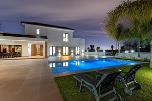 A modern two-story house with a swimming pool, outdoor seating, and a well-lit patio area. - Palm Breeze Villa by Fidalsa (Catral)