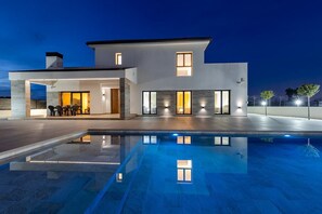 A modern two-story house with a swimming pool, outdoor seating, and large windows. - Palm Breeze Villa by Fidalsa (Catral)