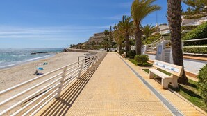 A beachside promenade with a tiled walkway, benches, palm trees, and a clear view of the sea. - Fidalsa Famous Spot by Fidalsa (Orihuela)