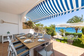 A dining area with a table set for four, outdoor seating, and a view of the sea. - Fidalsa Famous Spot by Fidalsa (Orihuela)