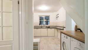 A kitchen with a washing machine, a window, and a sink. - Beau Jardin (Telford)