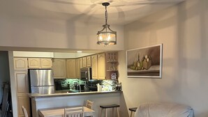 Une cuisine moderne avec un coin repas, un canapé et un tapis.